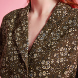 Close-up of olive floral print and tailored collar on vintage-inspired dress
