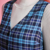 Close-up of blue plaid cotton jumper dress showing deep V-neckline, sleeveless bodice and navy aqua cream plaid