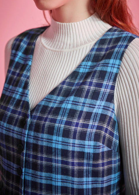 Close-up of blue plaid cotton jumper dress showing deep V-neckline, sleeveless bodice and navy aqua cream plaid