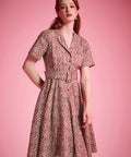 Woman wearing vintage cotton floral dress with flowing fit-and-flare silhouette