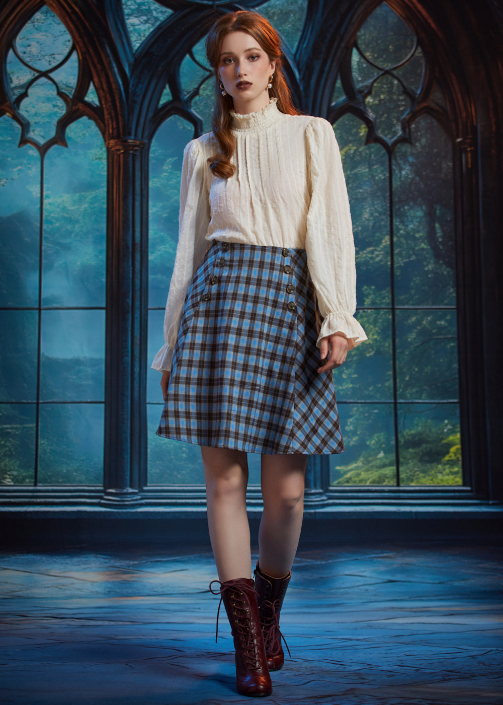 Full-length view of woman wearing a vintage-inspired blue plaid flare skirt with an ivory blouse and burgundy lace-up boots