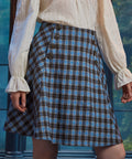 Front close-up of woman wearing the Sailor Flare Skirt in Study Blues with double button details and blue brown plaid pattern