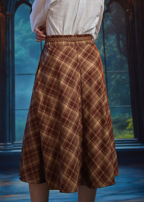 Back view of woman wearing a brown and tan plaid midi skirt showing sweeping A-line silhouette and braided belt