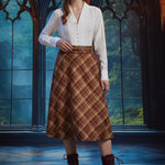 Full-length view woman wearing the ModCloth Turning the Page brown plaid midi skirt with white blouse, braided belt and burgundy boots