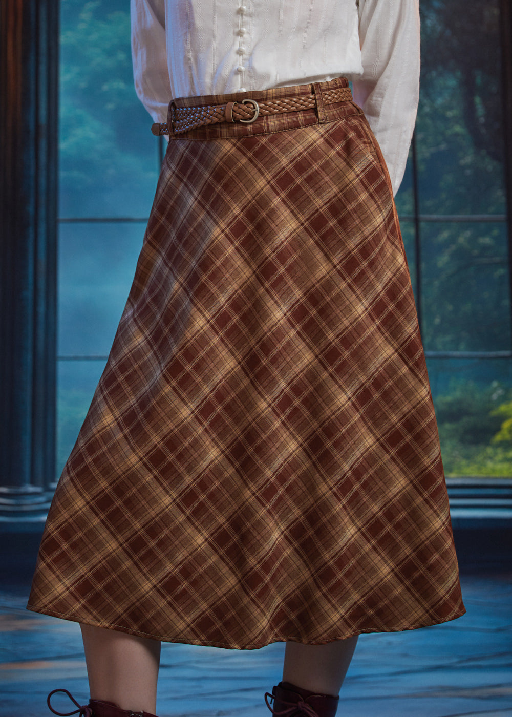 Angled view of woman wearing high-waisted brown plaid midi skirt with braided belt and bias-cut A-line silhouette