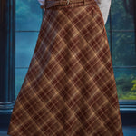 Angled view of woman wearing high-waisted brown plaid midi skirt with braided belt and bias-cut A-line silhouette