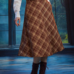 Woman wearing a vintage-inspired brown plaid A-line midi skirt with braided waist belt and burgundy lace-up boots