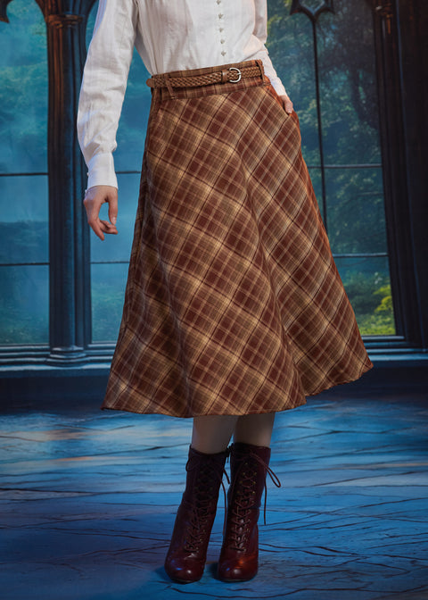 Woman wearing a vintage-inspired brown plaid A-line midi skirt with braided waist belt and burgundy lace-up boots