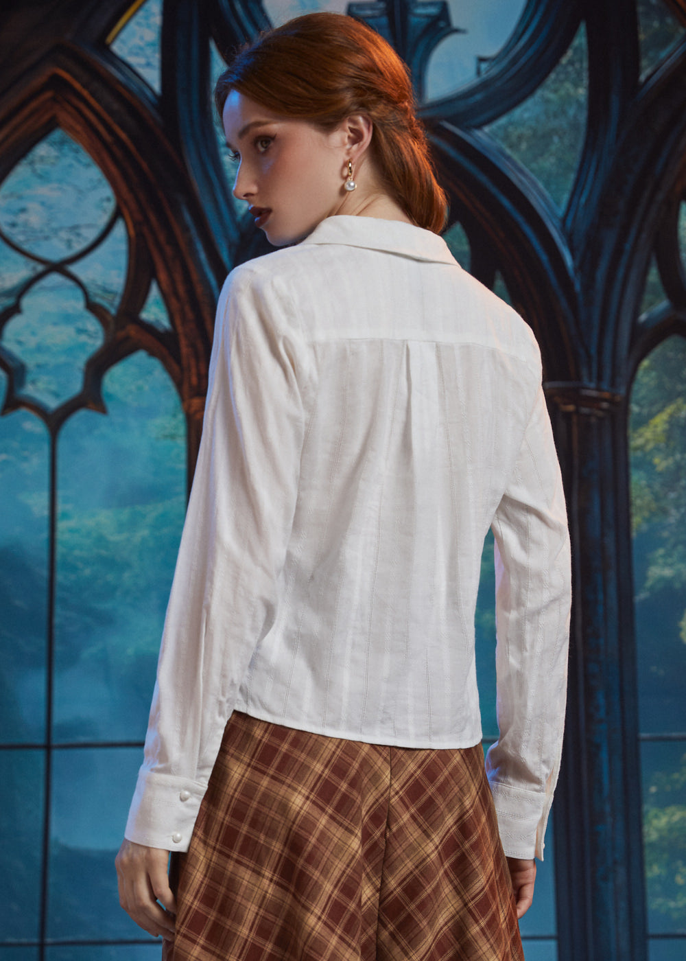 Back view of woman wearing ivory long sleeve blouse showing shawl collar, back yoke, center pleat and textured stripe fabric