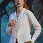 Woman wearing Vintage Ivory blouse with pearl-style buttons and flyaway front hem, styled with brown plaid skirt