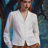 Woman wearing Vintage Ivory pearl button blouse, front view showing long sleeves, shawl collar and flyaway hem