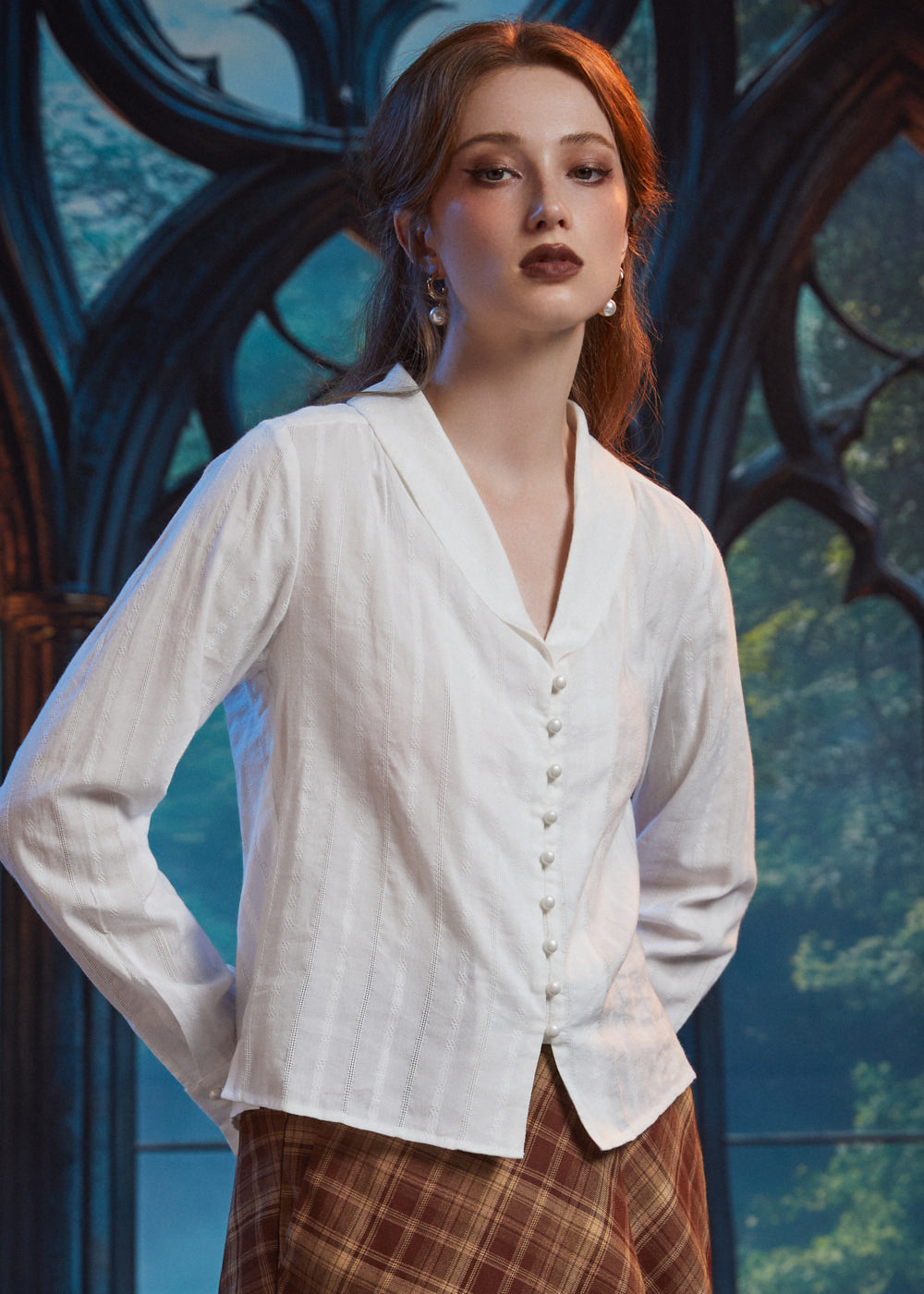Three-quarter view of woman wearing ivory pearl button blouse showing V-neck shawl collar, long sleeves and dobby stripe texture