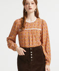 Woman wearing brown ditsy floral blouse with gathered yoke, lace trim and button cuff sleeves