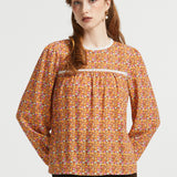Woman wearing brown floral prairie blouse with long sleeves and lace-trimmed gathered yoke