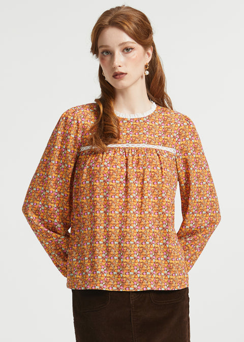 Woman wearing brown floral prairie blouse with long sleeves and lace-trimmed gathered yoke
