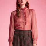 Front view of woman wearing dusty rose striped blouse with high ruffle neck, button placket, and long blouson sleeves