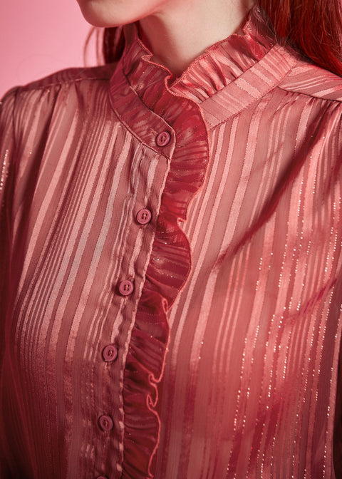 Close-up of dusty rose ruffle blouse showing the high ruffled neckline, button front, gathered shoulder, and shimmering tonal stripes
