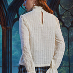 Back view of woman wearing ivory cotton blend poet blouse showing high smocked collar, keyhole opening and ruffled cuffs