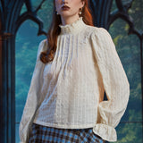 Woman wearing Poetry in Motion cream color blouse with high ruffled neckline and softly gathered long sleeves