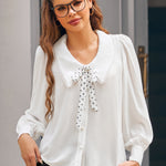 Woman wearing Petal Picnic ivory blouse with oversized collar, polka dot necktie and long blouson sleeves