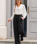 Full-length view of woman wearing ivory tie neck blouse with black wide-leg trousers and red heels