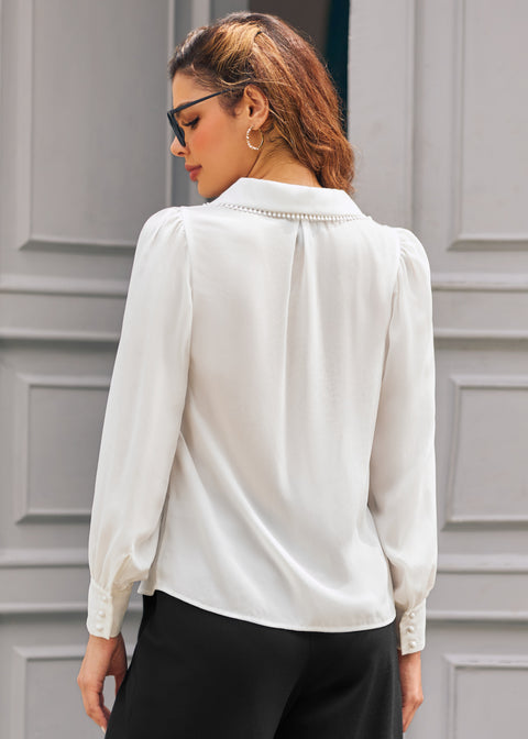 Back view of ivory long sleeve blouse showing oversized collar with pom-pom trim and gathered shoulders