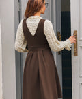 Back view of woman wearing the brown Layer It On Me Jumper showing its deep V-back, defined waist and pleated A-line skirt.