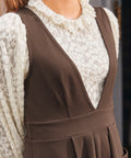 Close-up of woman wearing the brown Layer It On Me Jumper over an ivory lace blouse, showing the deep V-neck and wide waistband.