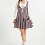 Full-length view of woman wearing vintage houndstooth jumper dress by ModCloth