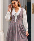 Woman wearing ModCloth houndstooth jumper dress layered over white blouse
