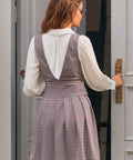 Back view of woman wearing houndstooth jumper dress with deep V-back