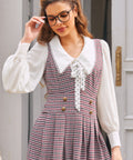 Woman wearing burgundy houndstooth jumper dress with deep V-neck and gold-tone buttons