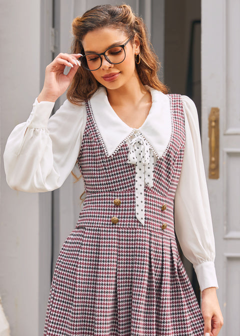 Woman wearing burgundy houndstooth jumper dress with deep V-neck and gold-tone buttons