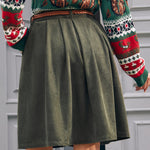 Back view of women's olive green corduroy A-line skirt with pleated silhouette