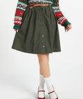 Women's olive corduroy button-front skirt styled with sweater and belt