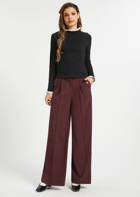 Woman wearing Mahogany Wine wide leg corduroy pants with black long sleeve top and black heels