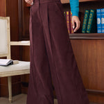 Woman wearing Mahogany Wine high waisted wide leg pants showing front pleats, center creases and button pocket details