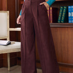 Three-quarter view of woman wearing Mahogany Wine high waisted corduroy wide leg pants with teal sweater in library