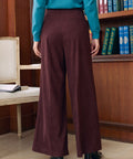 Back view of woman wearing Mahogany Wine corduroy wide leg pants showing wide-leg fit and back welt pocket