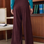 Back view of woman wearing Mahogany Wine corduroy wide leg pants showing wide-leg fit and back welt pocket