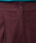 Close-up of Mahogany Wine corduroy pants showing double-button waistband, front pleat and textured fabric