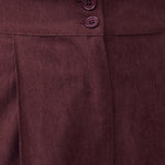Close-up of Mahogany Wine corduroy pants showing double-button waistband, front pleat and textured fabric