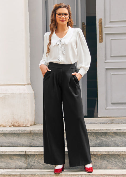 Woman wearing black high waisted wide leg pants with pleated front, white blouse and red heels