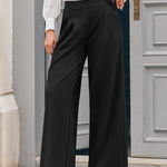 Woman wearing black high waisted wide leg trousers with front pleats and red block heel shoes