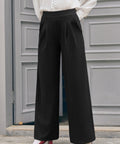 Woman wearing black wide leg pants with white vintage-inspired blouse and red heels