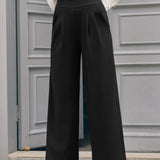Woman wearing black wide leg pants with white vintage-inspired blouse and red heels