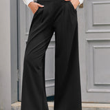Woman wearing black wide leg trousers with high waist and hands in functional side pockets