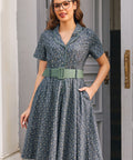 Woman wearing Rustic Elegance floral cotton shirt dress with sage belt and hand in side seam pocket