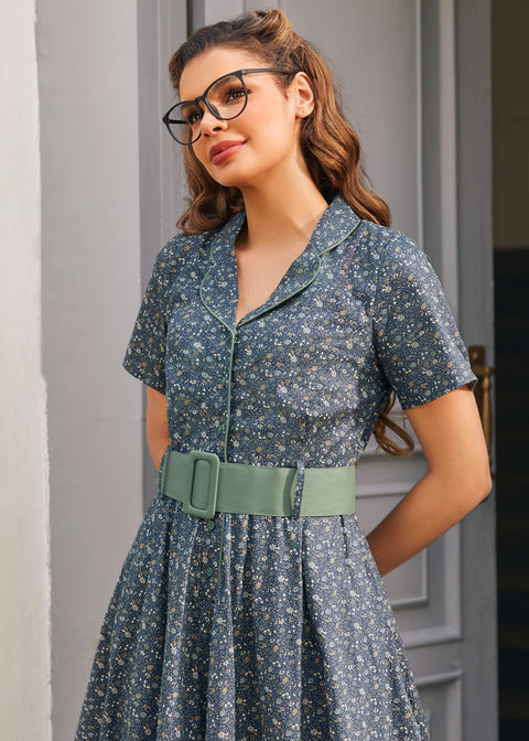 Close-up of woman wearing Rustic Elegance cotton floral dress in Forget Me Not with side pocket and sage green belt