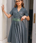 Woman wearing Rustic Elegance blue floral cotton shirt dress with sage belt, short sleeves and full fit-and-flare skirt